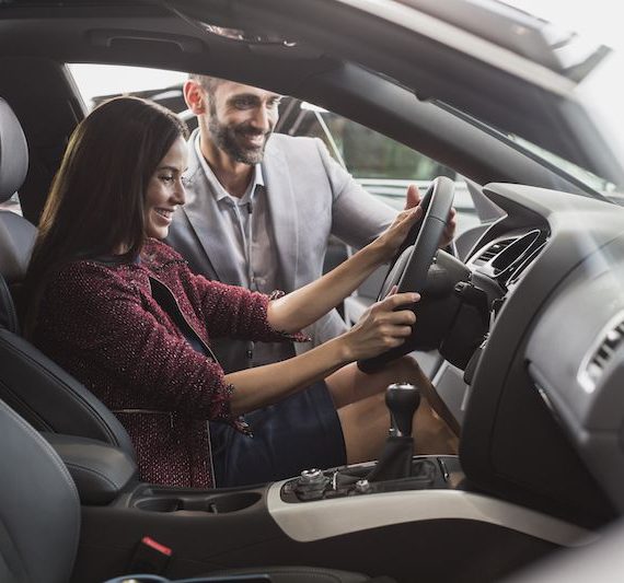 salesman and woman in car happy