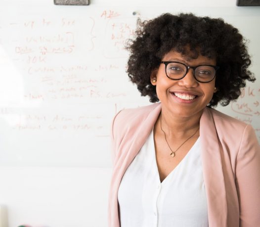 female teacher infront of whiteboard and students